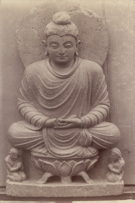 Ancient statue of a Buddha seated on a lotus throne, symbolizing the roots of lotus tea's history